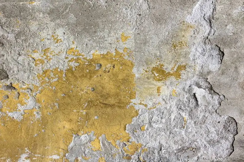 old cracked yellow plaster on the cement wall