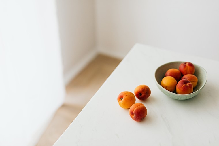 fresh apricots placed on white table