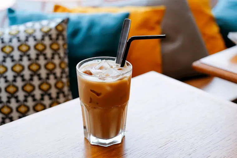 glass of latte with straw background