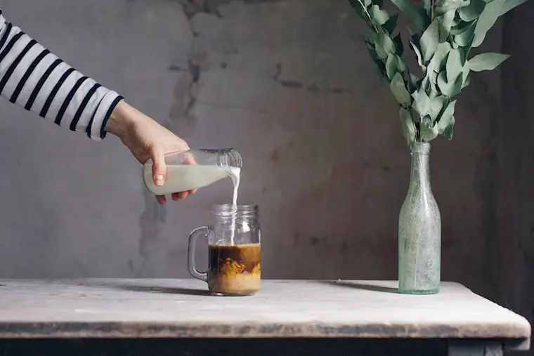 woman pouring latte in glass mug wallpaper